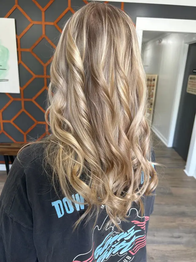 Loose curled balayage highlights blending into a natural brunette base