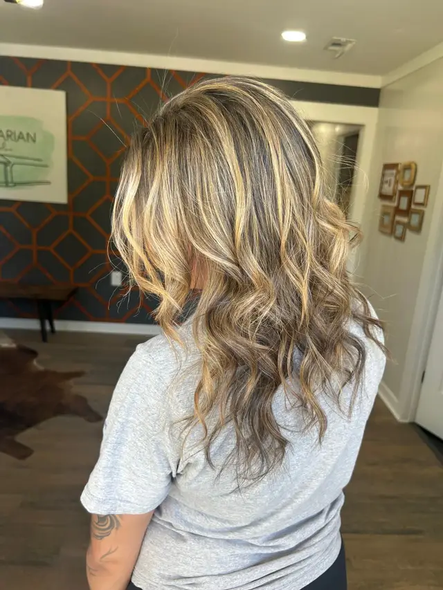 Dimensional blonding highlights with soft waves and natural root shadow