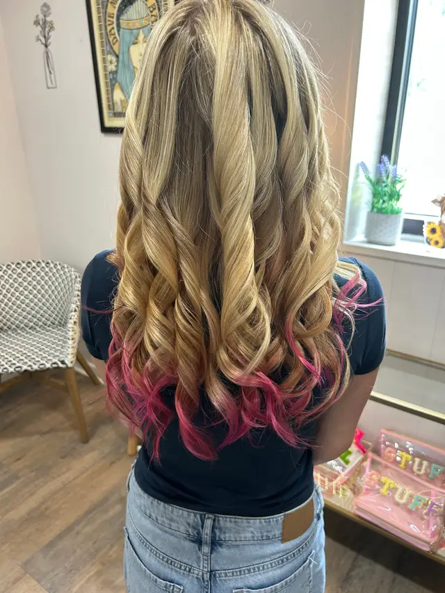 Blonde balayage with a vivid pink peekaboo color accent underneath